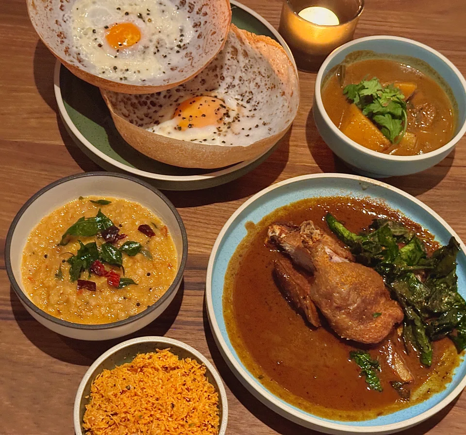 A spread of (clockwise) egg hoppers, butternut squash curry, Jaffna duck curry, coconut sambal and dahl.