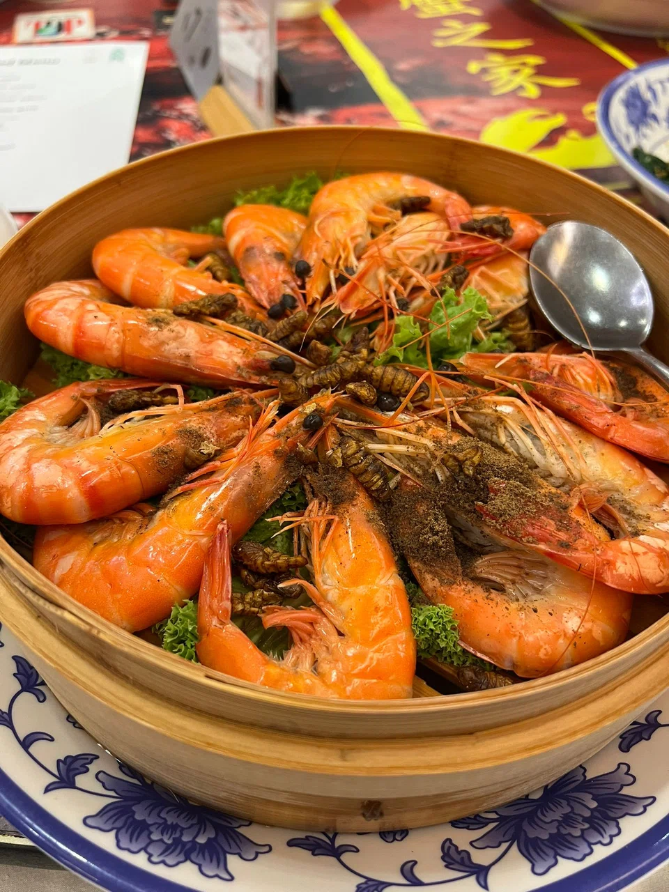 Next on the menu is fresh poached prawns garnished with silkworm pupae.