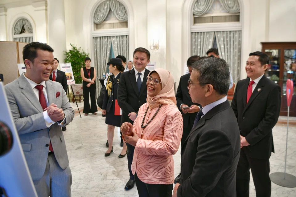 Cho Ming Xiu (left), who received the Leader of Good Award for his work with mental health organisation Campus PSY, speaking with President Halimah Yacob and Minister for Culture, Community and Youth Edwin Tong at the Istana on Oct 11, 2022.