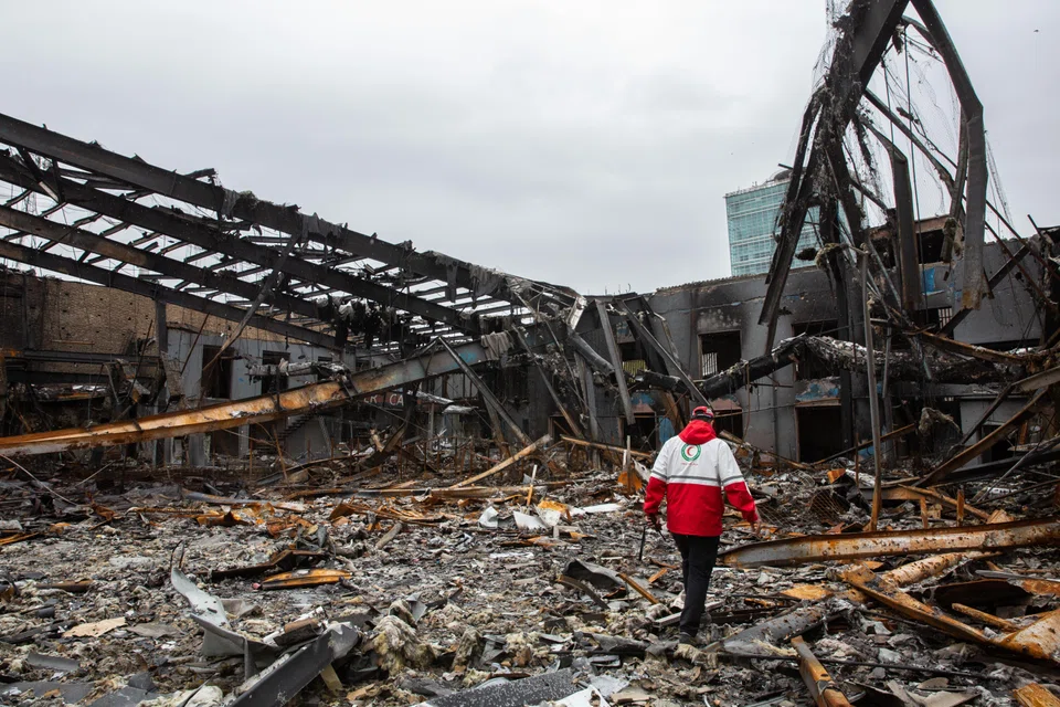 A Red Crescent worker steps through the ruins of an auto service centre that was targeted by US-Israeli airstrikes in Teheran, Iran, March 28, 2026.