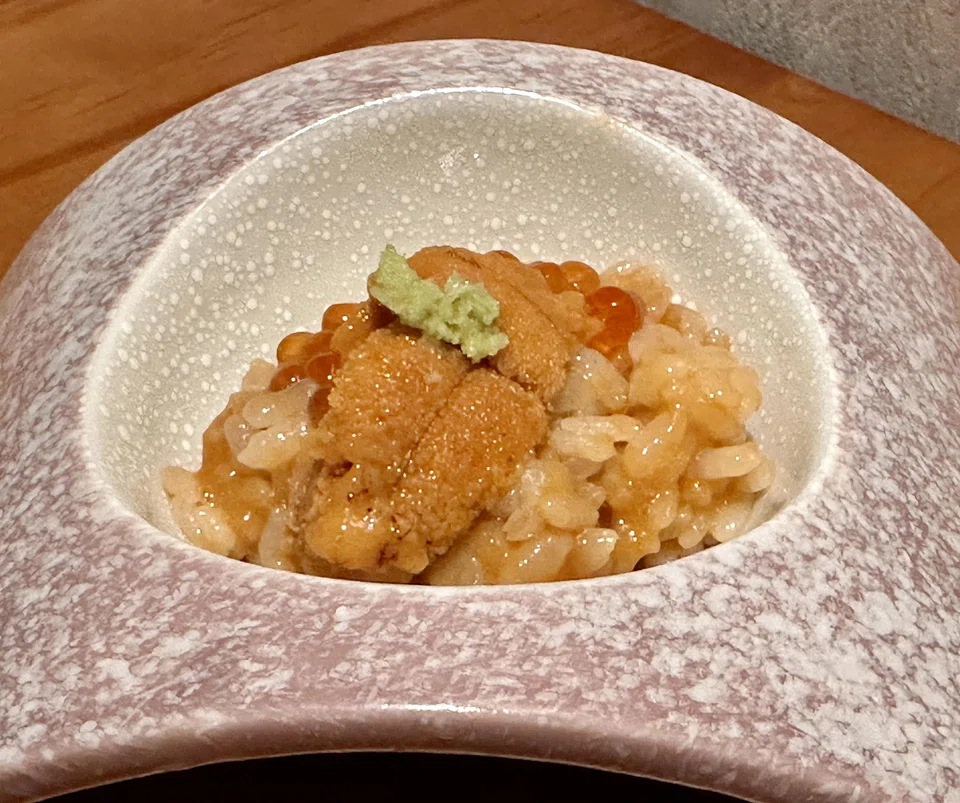 A bite-sized portion of chewy rice is mixed with uni to give it a glossy rich sheen.