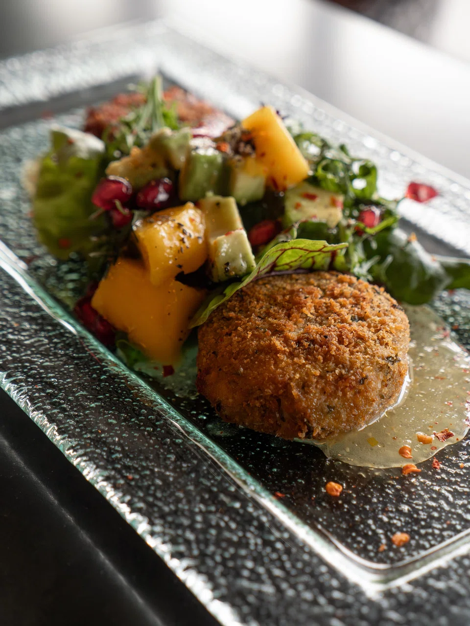 Deep-fried patties of mashed beetroot are drizzled in mango sauce.
