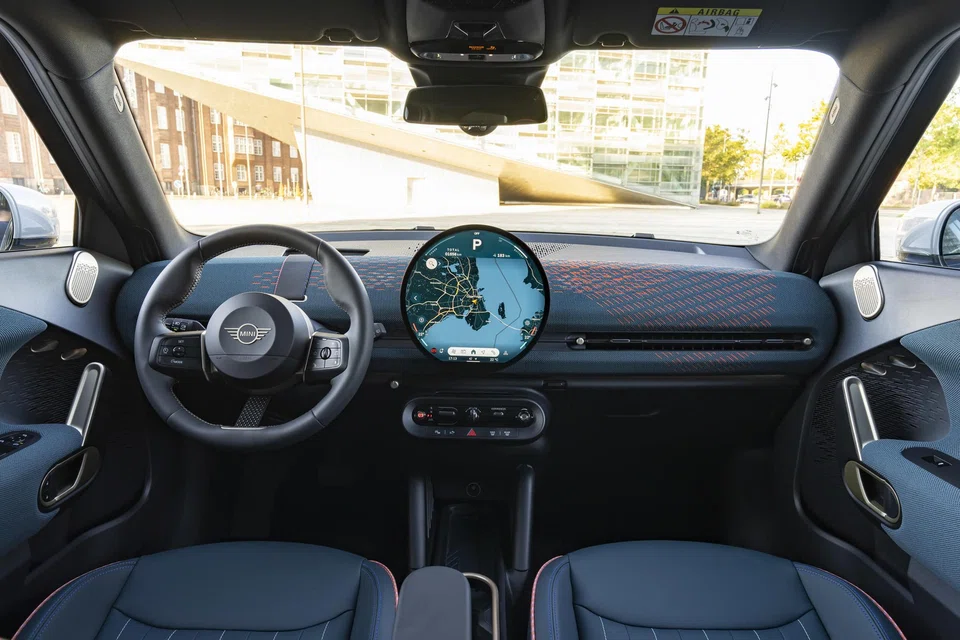 The dashboard is dominated by a massive, circular OLED screen.
