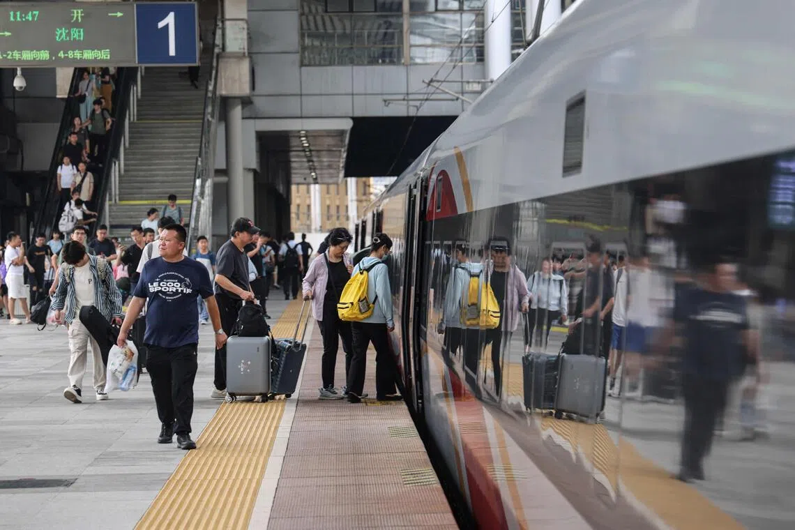 Passengers boarding a high- speed train in Dalian, in northeastern Liaoning province. In July and August, a record 943 million passenger trips were taken on China’s railways, up 4.7% year on year.