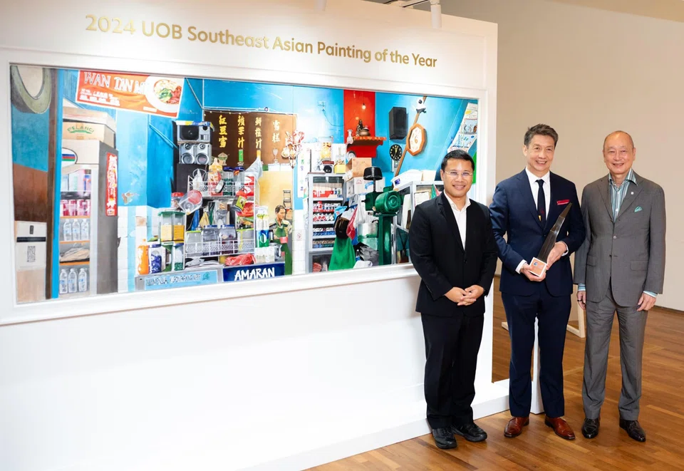 Yong Wee Loon (centre), winner of 2024 UOB Painting of the Year (Singapore) and South-east Asian Painting of the Year awards, with Minister for National Development Desmond Lee (left) and Wee Ee Cheong, deputy chairman and CEO of UOB. Behind them is Yong's painting.