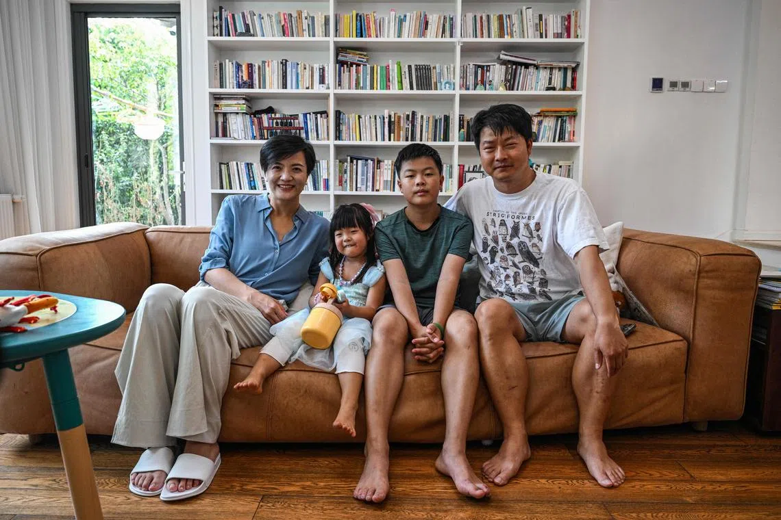 Stay-at-home dad Chen Hualiang (right), his wife Mao Li (left), and children at their home in Shanghai, China, Aug 9, 2024