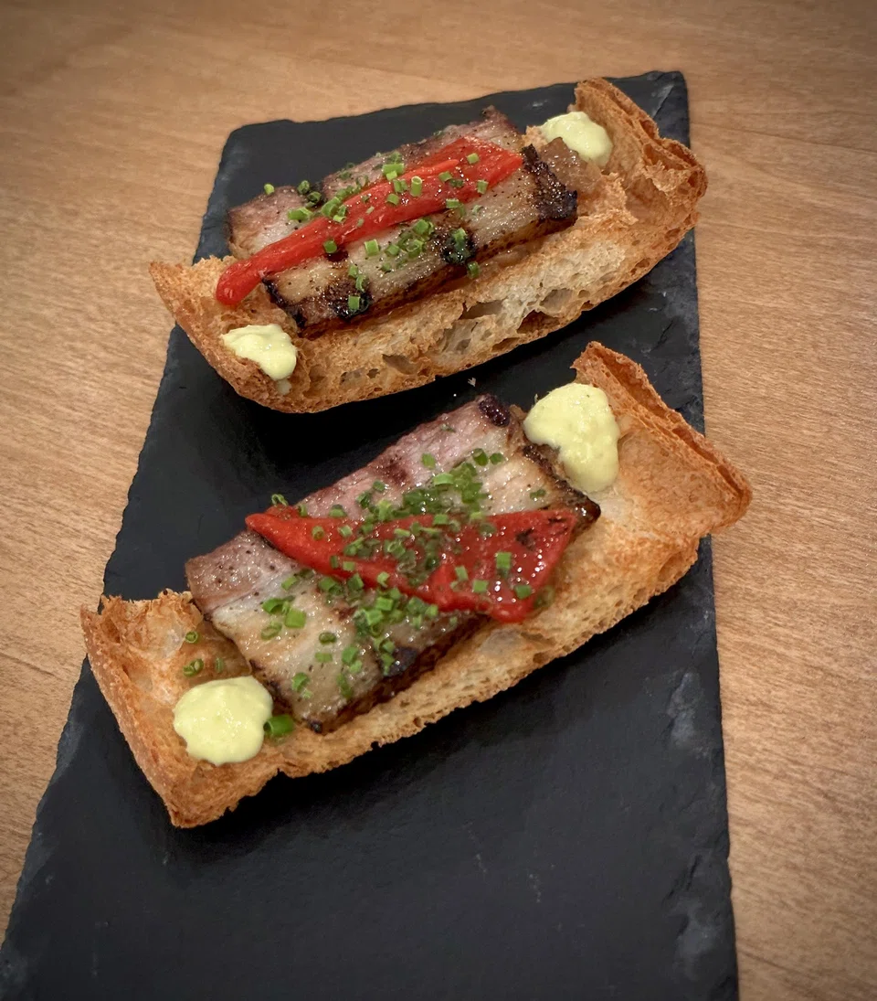 The tender pork belly on crisp baguette slices topped with roasted peppers is passable.