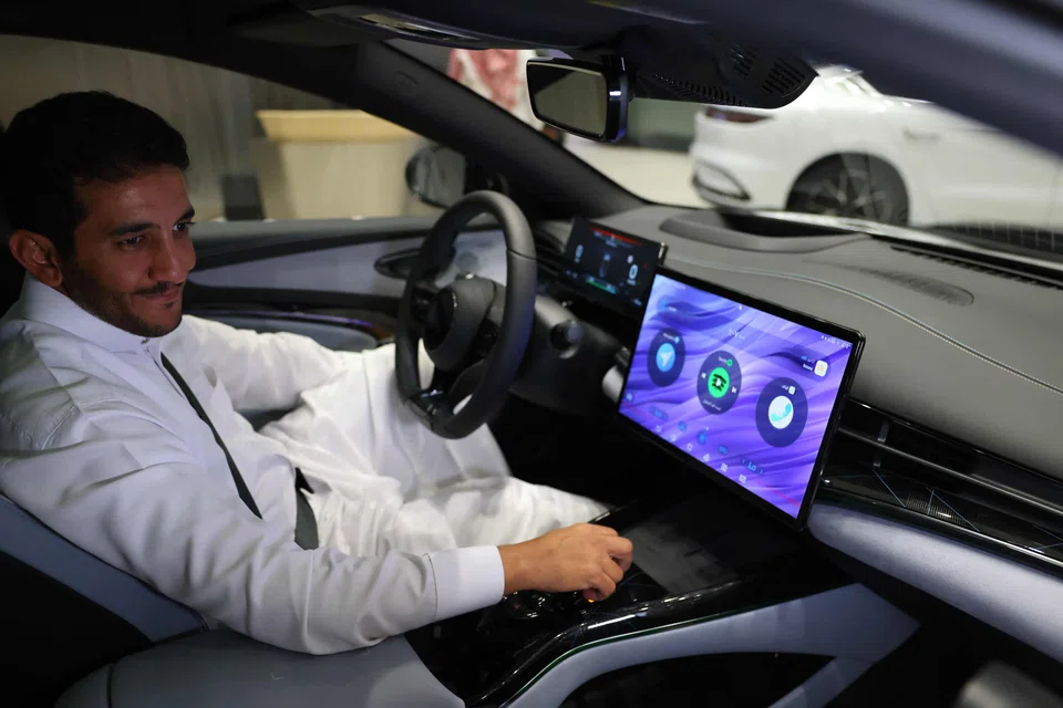 A man inspects an electric car at a showroom in Riyadh, Saudi Arabia, June 8, 2024. Although the EV market in the world's largest oil exporter remains small compared with the United States and China, it tripled last year to nearly 800 cars, according to Saudi business news outlet Al-Iqtisadiyah. 