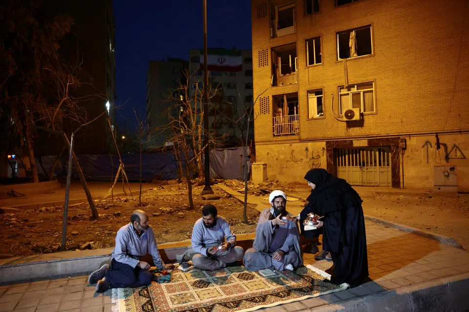 Iranian women deliver iftar meal packages to the volunteer team, that helps people affected clean and restore homes after strikes in Teheran on Mar 18.
