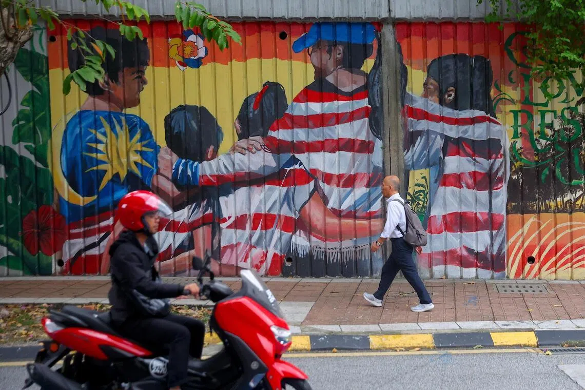 epa12684627 A man pass by the national flag grafitti in Kuala Lumpur, Malaysia, 27 January 2026. The Malaysian ringgit traded at 3.9540 against the U.S. dollar on 27 January, with positive economic data reinforcing its strength, Malaysia’s Prime Minister and Finance Minister Anwar Ibrahim said.  EPA/FAZRY ISMAIL
