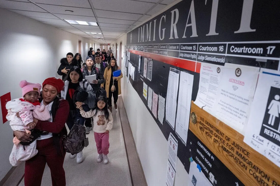 Foreign nationals walk through the hallway at US immigration court in Manhattan, New York City, Jan 15, 2026. 