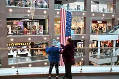 (FILES) A woman and a child look at shops in a mall on Black Friday in Arlington, Virginia on November 29, 2024. US consumer inflation ticked up for a second consecutive month in November 2024, driven by food prices and other sectors, according to government data published Wednesday, complicating the Federal Reserve's rate cut deliberations. (Photo by ROBERTO SCHMIDT / AFP)
