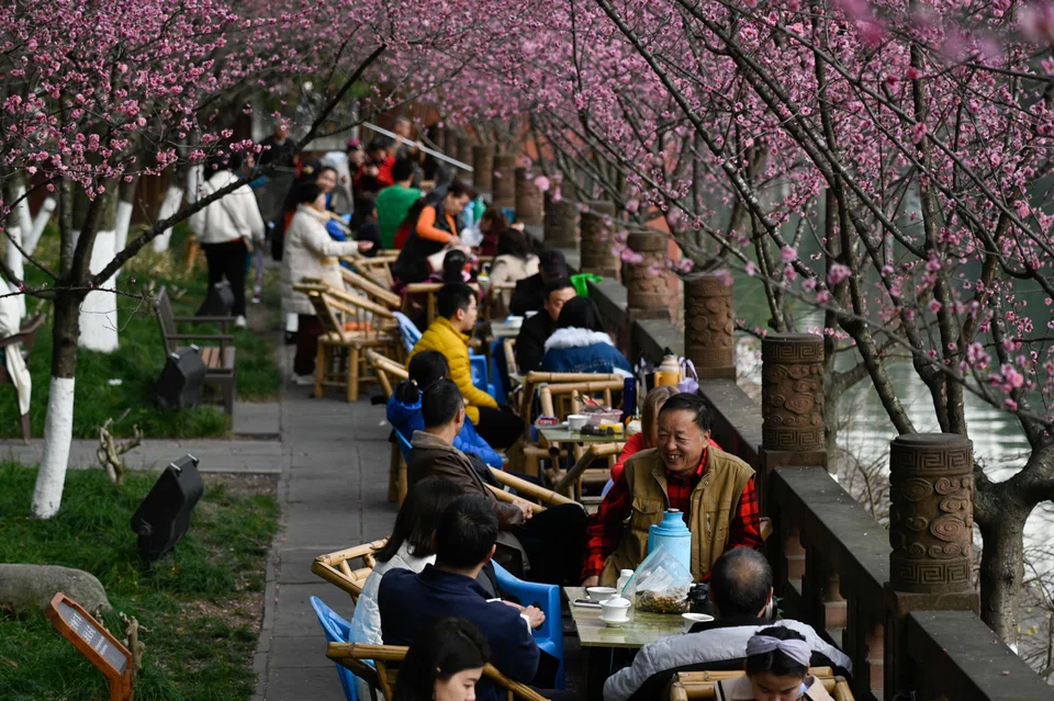 People sitting along a river at a park in Chengdu, Sichuan’s vibrant 3,000 years-young capital.
