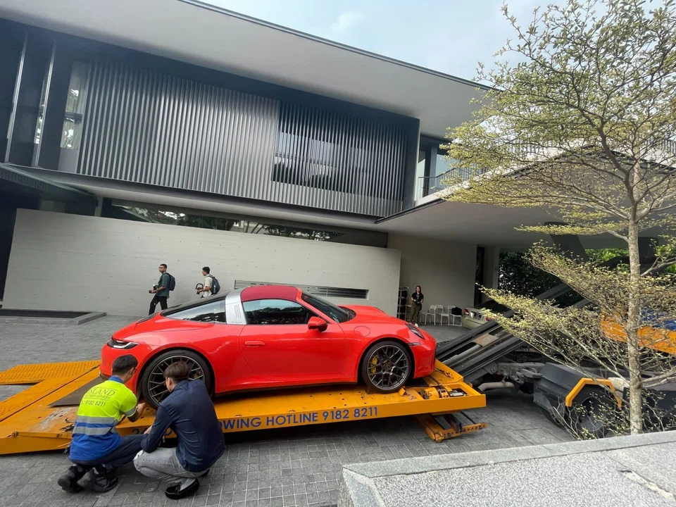 A red Porsche 911 Targa is among the four vehicles towed away from a Good Class Bungalow where one of the foreign nationals linked to the recent money-laundering case had resided.