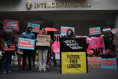 Climate activists hold placards during a protest against the Rosebank oil field project in the North Sea off the coast of Scotland on Oct 18, 2023