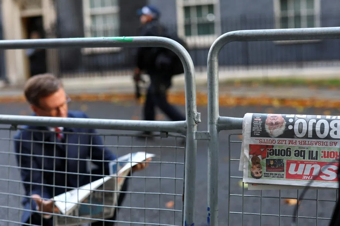 A newspaper, featuring an image of former British Prime Minister Boris Johnson, rests on a fence outside 10 Downing Street in London, October 21, 2022. 