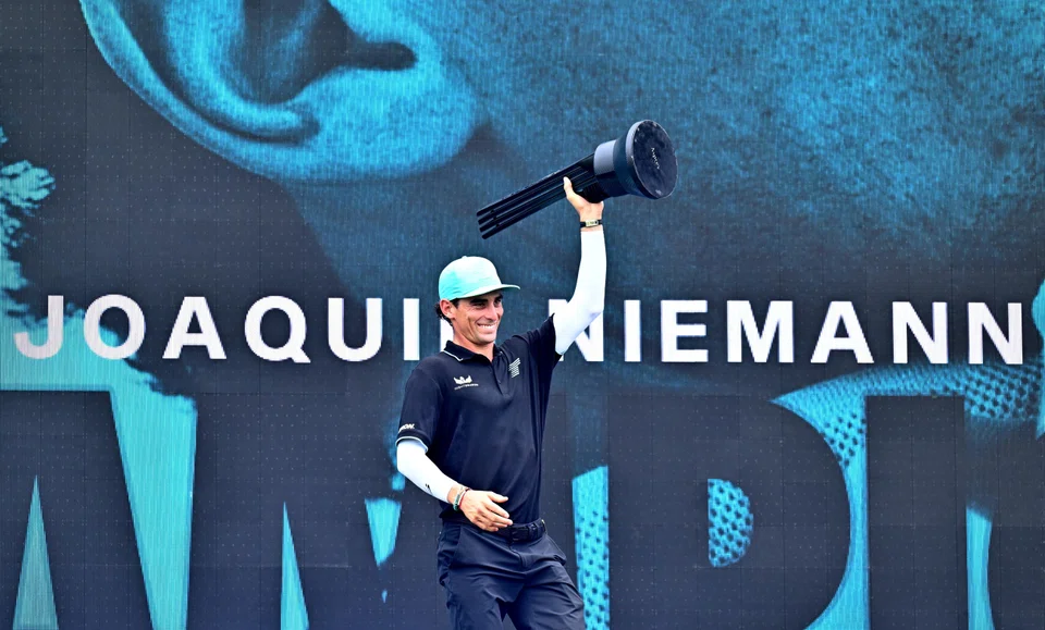 Niemann celebrating with the trophy on the podium after winning the LIV Golf Singapore on Sunday.