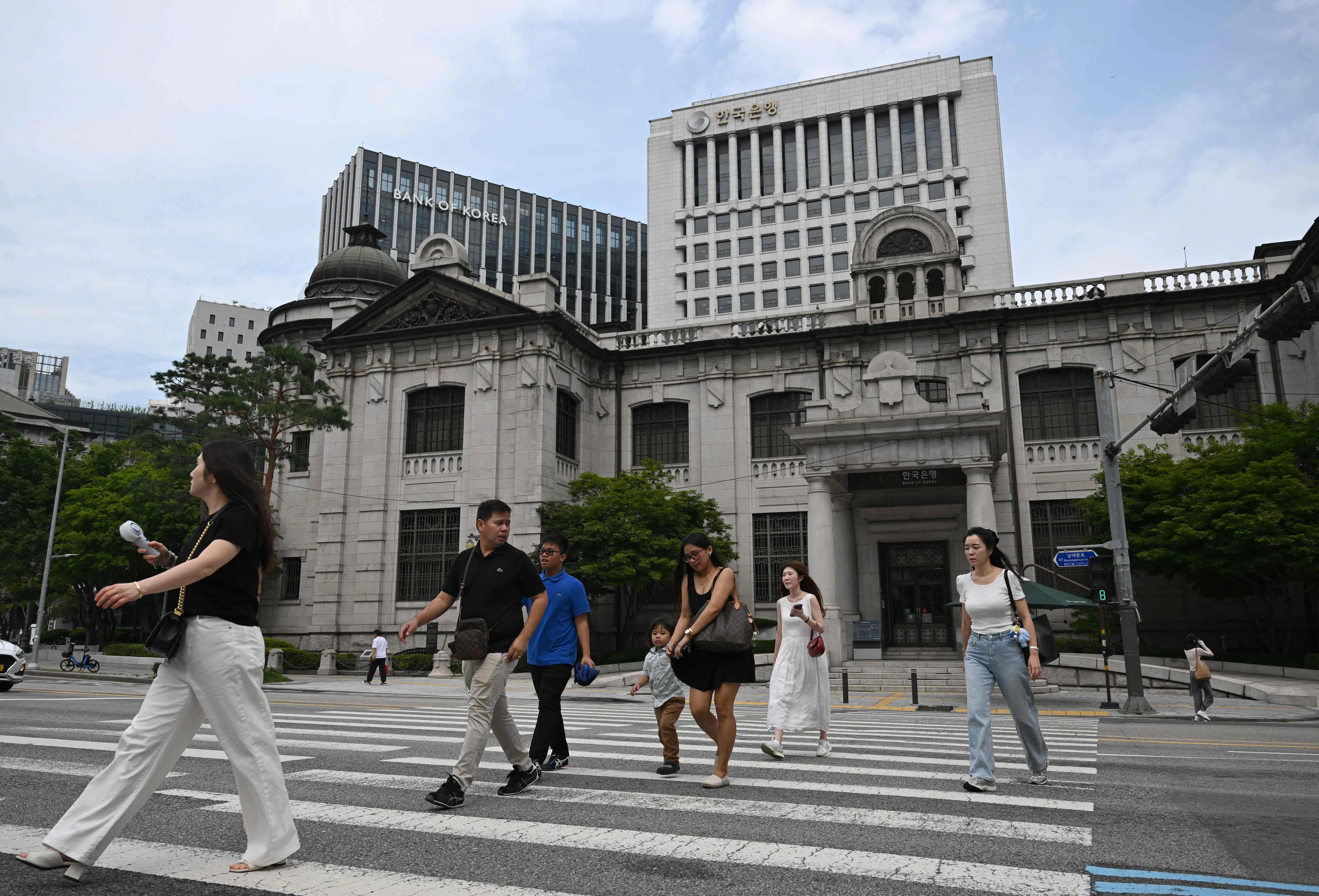 The Bank of Korea  says it will hold rates for the time being as it monitors household debt risks and the impact of US tariffs.