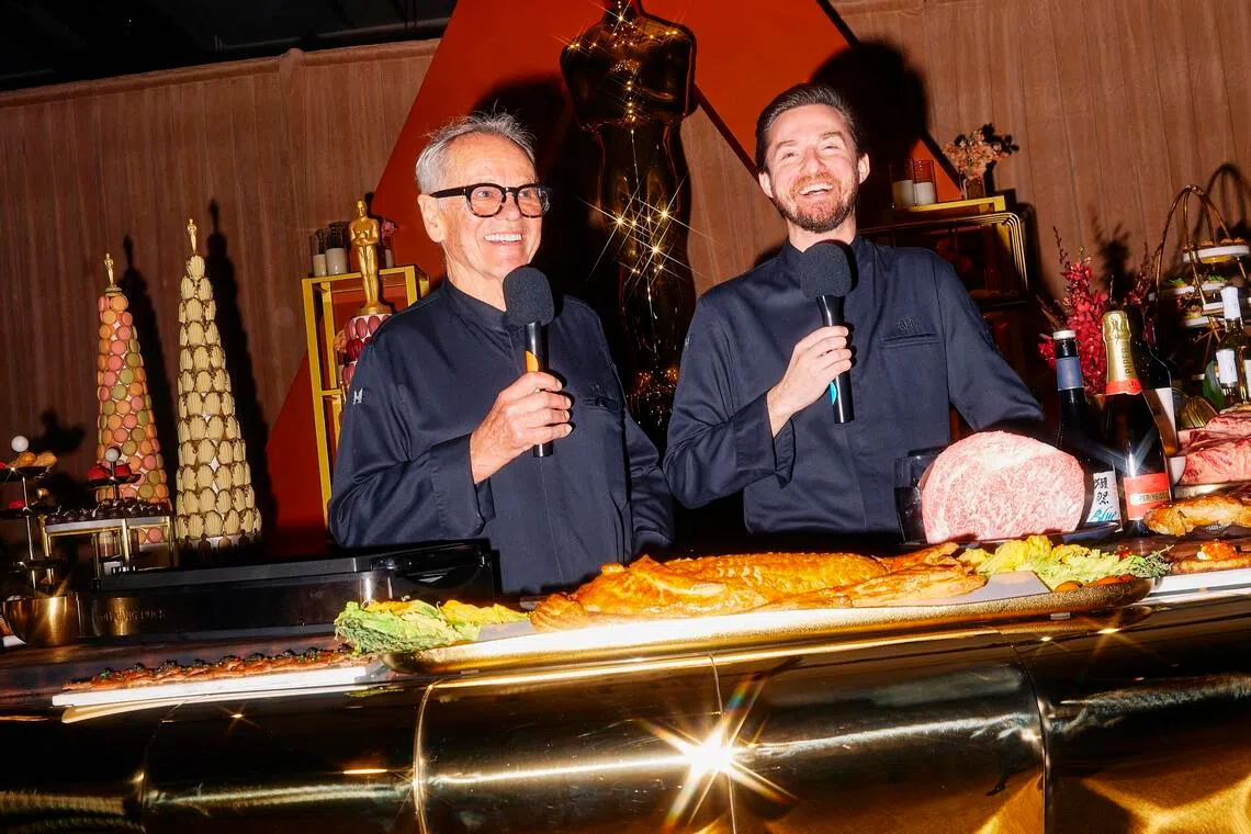 Wolfgang Puck (left) and his son Byron speaking about food preparations during a media preview in Los Angeles on Mar 13.