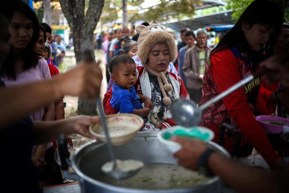 Displaced people queue for food at a school turned temporary shelter, amid clashes between Thailand and Cambodia along a disputed border area in Surin province, Thailand.