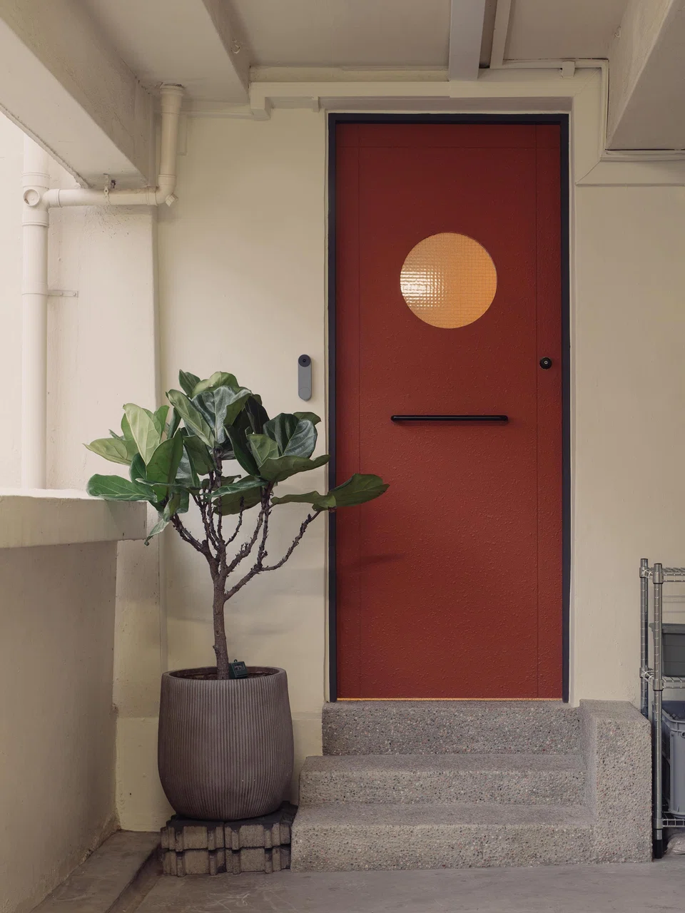 The terrcotta front door is fitted with a quaint porthole. 