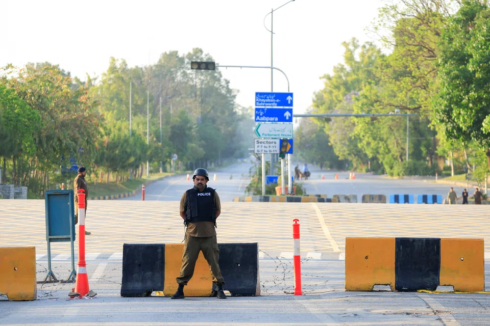Police officers stand guard on a road in Islamabad on Apr 21, as Pakistan prepares to host the US and Iran for the second phase of peace talks.