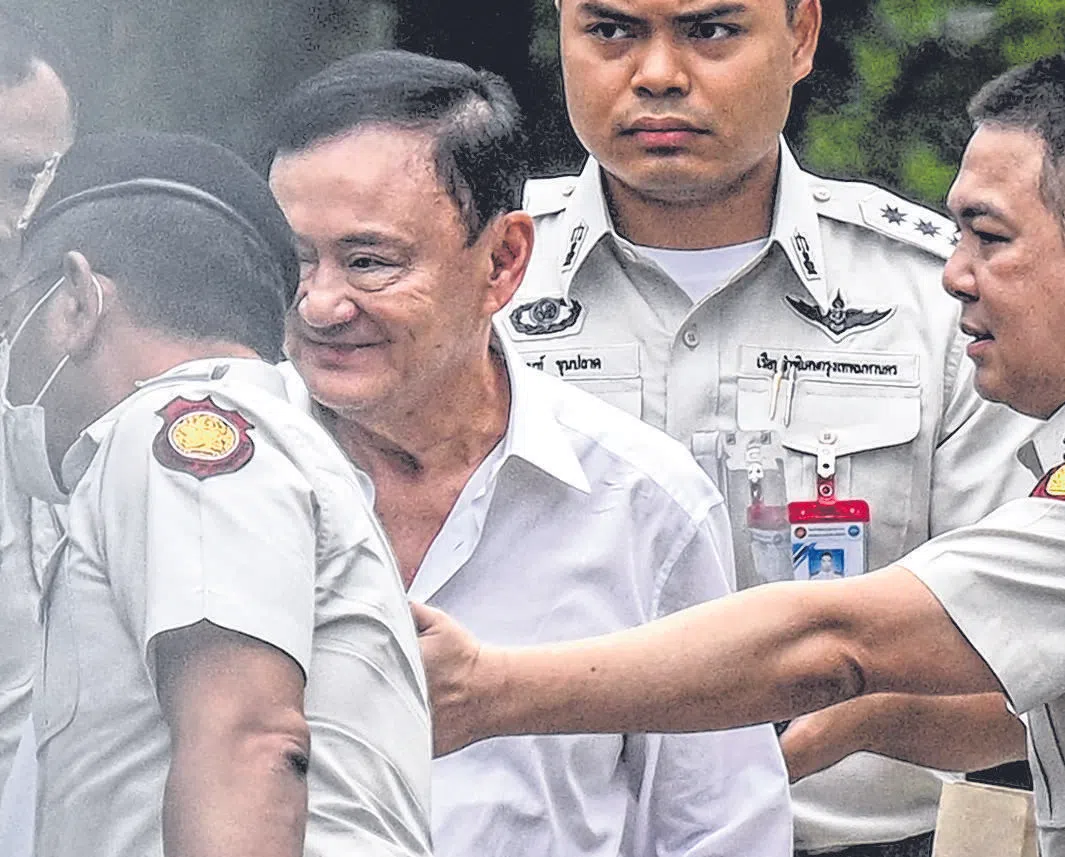 Thailand's former Prime Minister Thaksin Shinawatra (centre) is escorted into a police van outside the Supreme Court in Bangkok after he was sentenced to a year in prison, Sep 9, 2025.