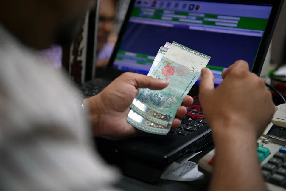 An employee at a Change Alley money changer counts a wad of Malaysian Ringgit banknotes on 14 November 2016. The Malaysian ringgit touched a 10-month low of 4.34 to the US dollar.
