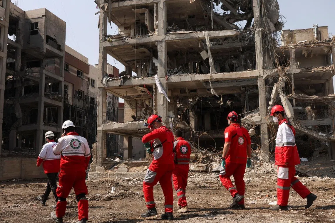 A Red Crescent rescue team works next to a building that was damaged by a strike, amid the U.S.-Israeli conflict with Iran, in Teheran, Iran, March 17, 2026. 