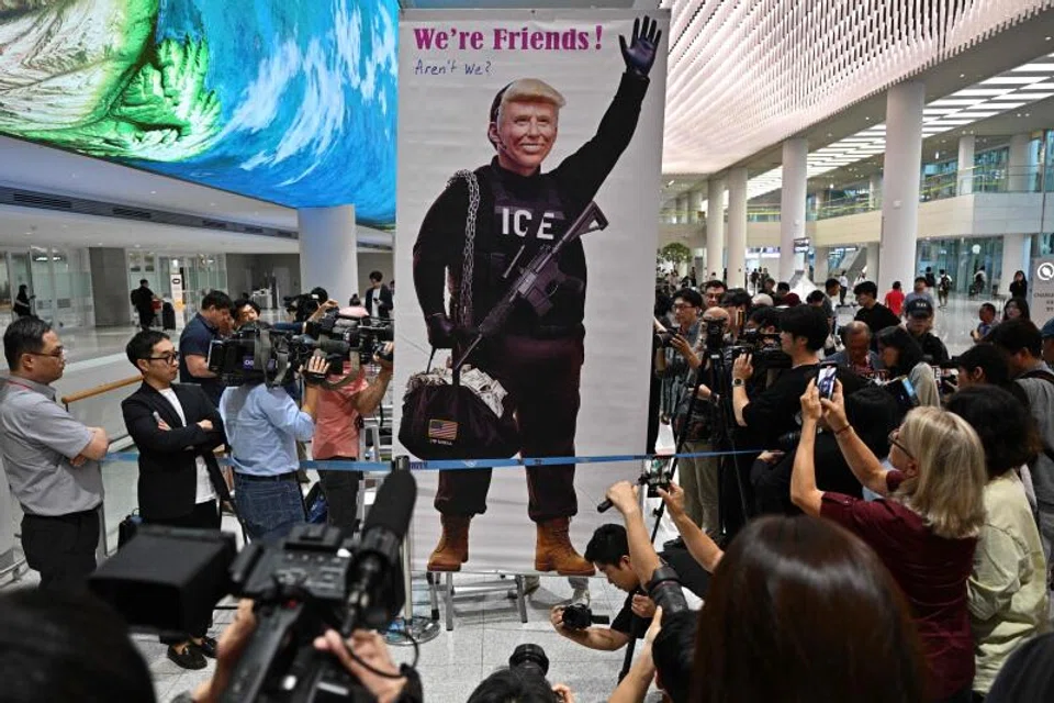 A banner showing US President Donald Trump is displayed by a protester at Incheon International Airport in Incheon to welcome workers detained in a US immigration sweep. 