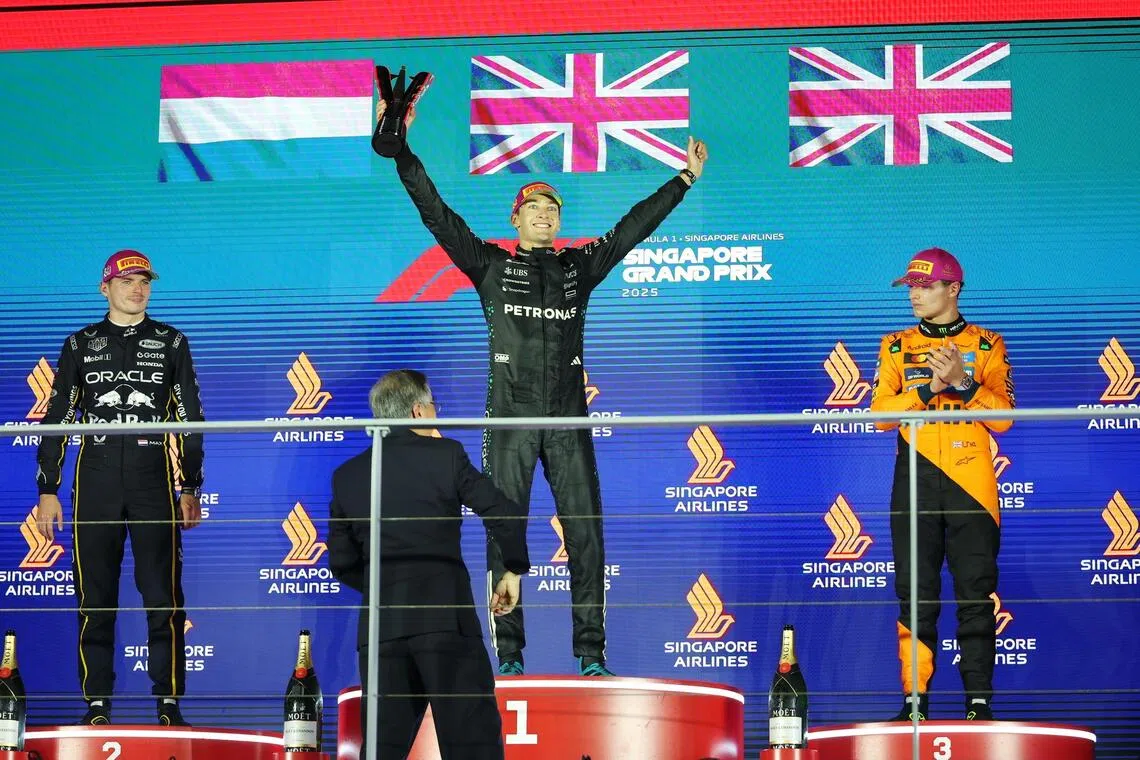 Race winner Mercedes driver George Russell (centre) of Britain, second-placed Red Bull Racing driver Max Verstappen (left) of the Netherlands and third-placed McLaren driver Lando Norris of Britain celebrating after the race.