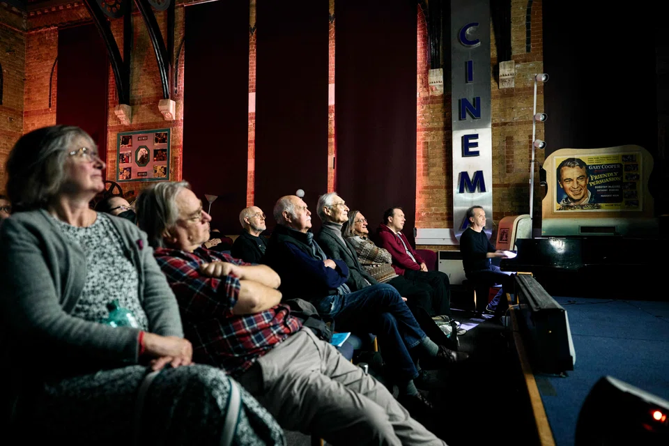 Small gatherings of dedicated silent movie lovers attending a projection of the Danish silent movie "The Mannequins" accompanied by a live piano performance, at the Cinema Museum, in London.
