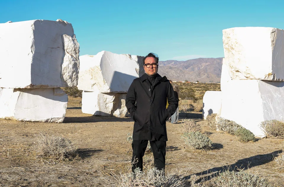 Mexican artist Jose Davila with his piece “The Act of Being Together”, which stacked colossal 16-tonne marble boulders that were quarried in the Chihuahua Desert of his nearby home country. .