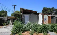 The 645-square-foot property was partially demolished when an enormous pine tree toppled over, crushing the front.