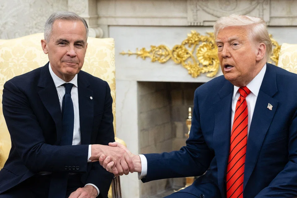 US President Donald Trump (right) and Canada's Prime Minister Mark Carney shake hands during a meeting in the Oval Office of the White House in Washington, D.C., May 6, 2025. 