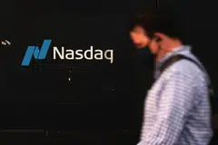 NEW YORK, NEW YORK - OCTOBER 12: People walk past the Nasdaq MarketSite on October 12, 2022 in New York City. The Nasdaq Composite Index yesterday hit its lowest level since July, slipping into a bear market for the second time this year.   Michael M. Santiago/Getty Images/AFP
