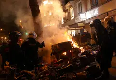 French riot police try to extinguish a fire amid clashes during a demonstration against the French government's pension reform, in Paris, France, March 25, 2023. 