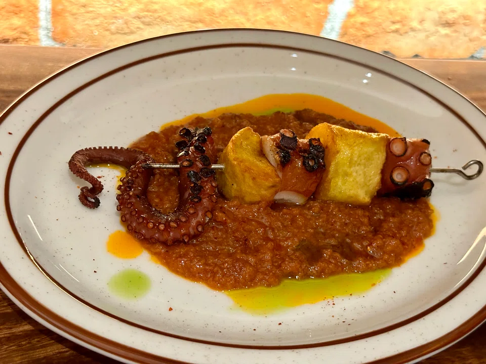 Octopus and potato on a skewer with sobrasada sauce.