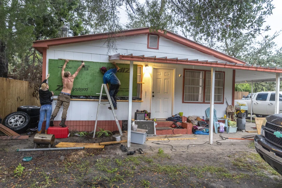 People boarding up windows to prepare for Hurricane Helene, in Old Town, Florida, Sept 25, 2024. 