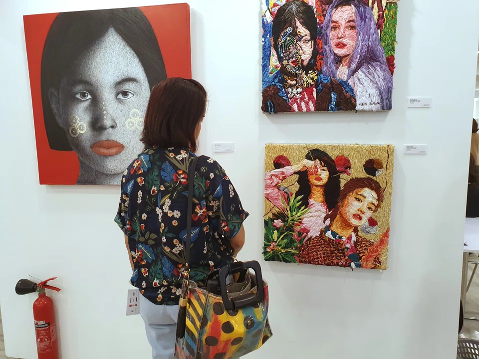 A woman viewing art paintings at The Affordable Art Fair Singapore 2019.