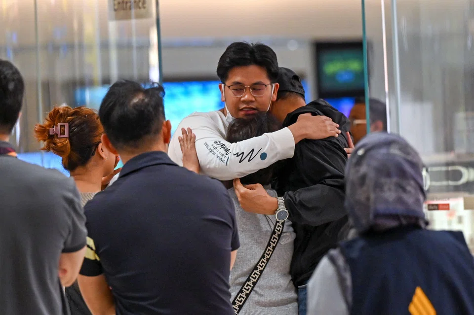 Passengers of Singapore Airlines flight SQ321 from London to Singapore, which made an emergency landing in Bangkok, greet family members upon arrival at Changi Airport in Singapore on May 22. 