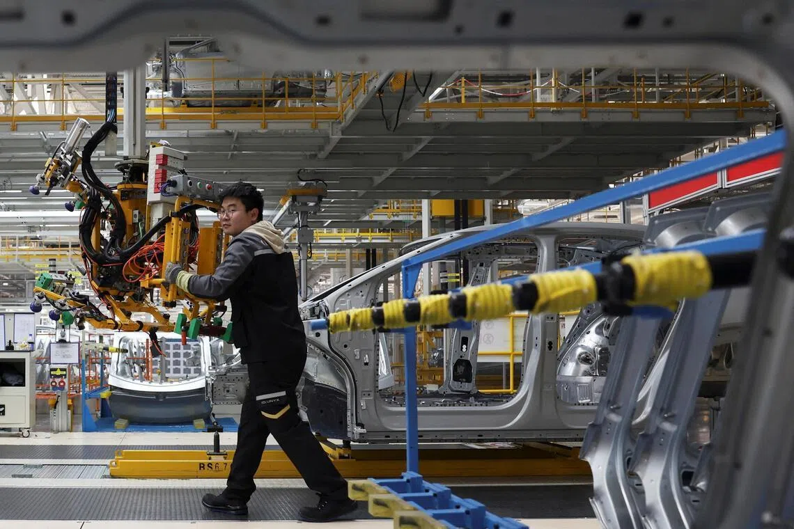 An employee works an electric vehicle production line at the Volkswagen Anhui factory in Hefei, China, Feb 4, 2026.