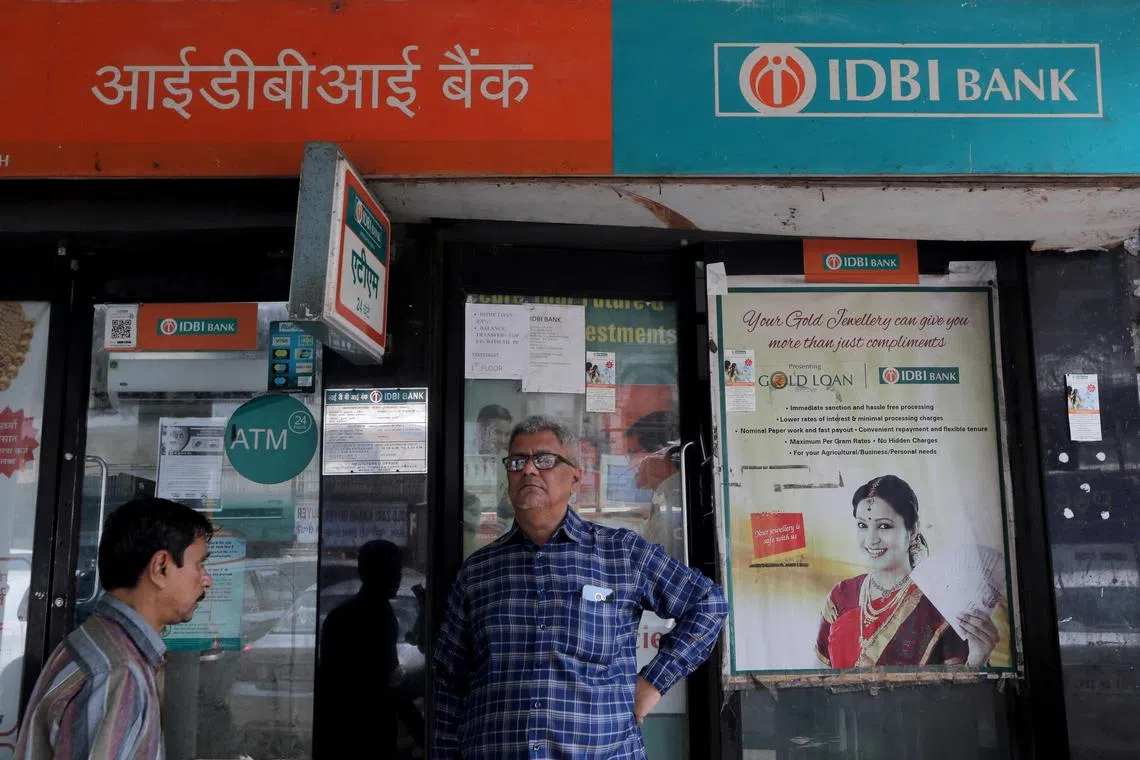 A man stands outside an IDBI Bank branch next to its ATM kiosk in Mumbai. After a record-breaking year in 2021, PE and VC investments totalled US$61.6 billion in 2022.