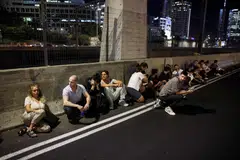 People taking cover by the side of a road in Tel Aviv as a siren sounds, after Iran fired a salvo of ballistic missiles at Israel on Oct 1. 