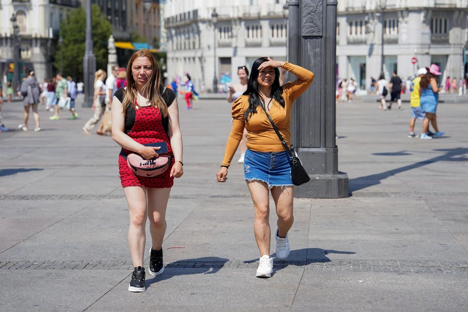 People walk through the Puerta del Sol during the second day of a heatwave, in Madrid, Spain, July 25, 2024. 