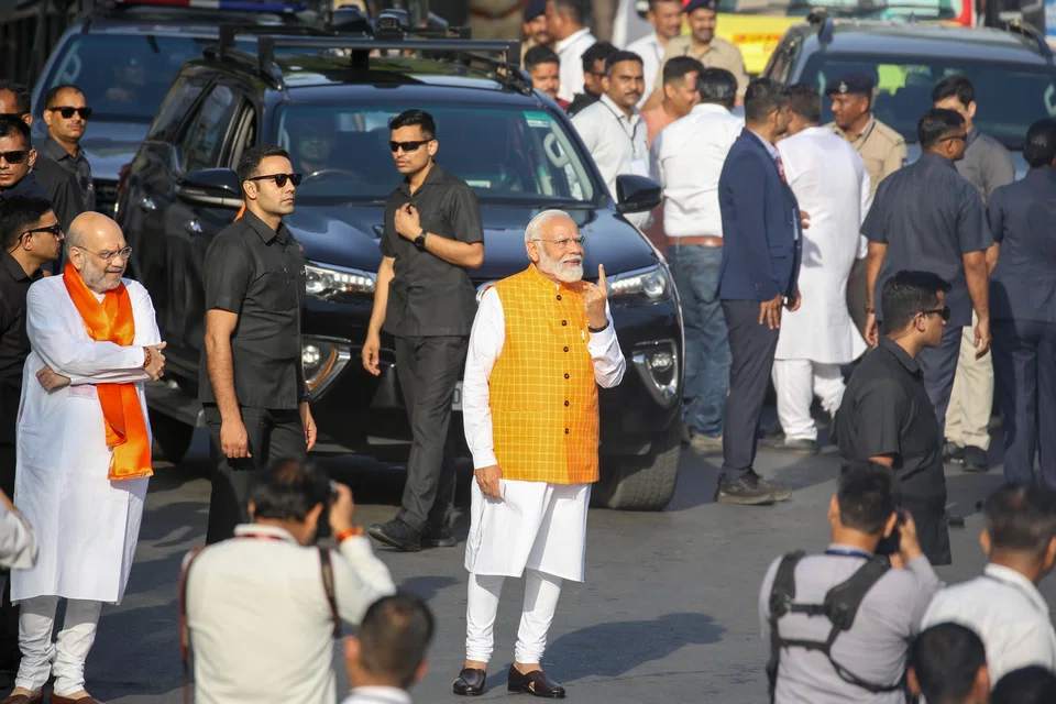 Indian Prime Minister Narendra Modi (centre) shows his ink-marked finger after casting his vote for the third phase of general elections in Ahmedabad, Gujarat, India, May 7, 2024. The Indian general elections are held in seven phases between April 19 and June 1, with the results announced on June 4, 2024.  