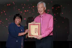 NTUC President K Thanaletchimi presenting the Distinguished Comrade of Labour Award to Senior Minister Lee Hsien Loong at the NTUC May Day Awards 2025.
