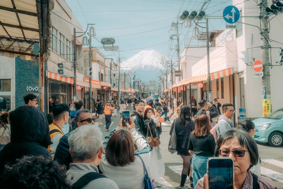 Tourists crowd a street in Fujiyoshida, Japan, April 9, 2026. Fujiyoshida is at the centre of Japan’s fight against badly behaved tourists. 