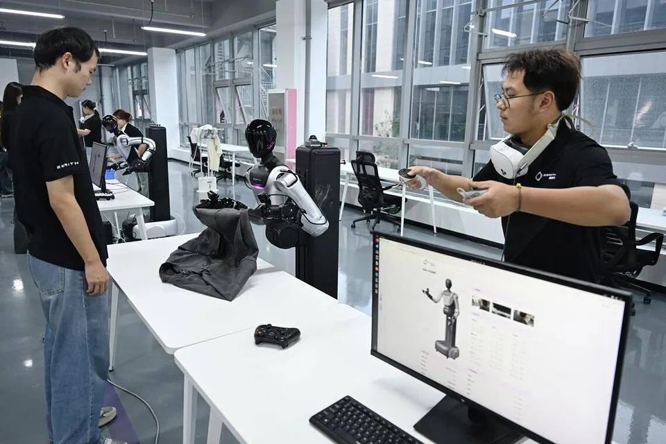 A human teleoperator controls a humanoid robot to fold a long-sleeved shirt at Zerith.