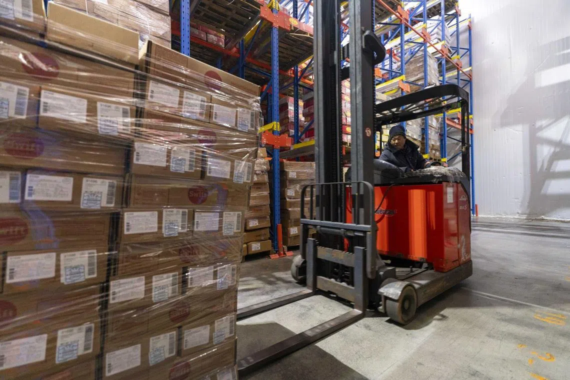 A worker uses a forklift to move boxes of imported pork from the US at a cold storage warehouse in Shanghai, China, on Wednesday, March 5, 2025. 